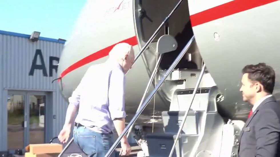 Julian Assange, uomo libero, sale sull'aereo che lo porterà in Australia | video