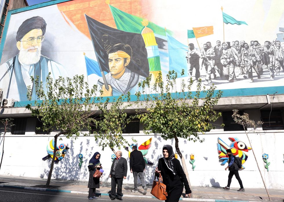 https://www.panorama.it/media-library/iraniani-a-teheran-sullo-sfondo-murales-propagandistico.jpg?id=53889756&width=980