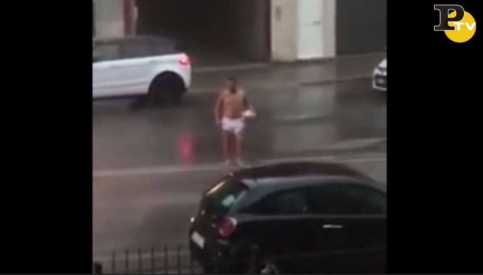 Uomo Si Aggira Per La Strada Nudo Sotto Il Diluvio Con Un Pallone In Mano Video Panorama 9299